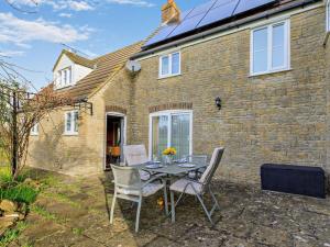 a table and chairs in front of a brick house at 1 Bed in Sherborne oc-93804 in Yetminster