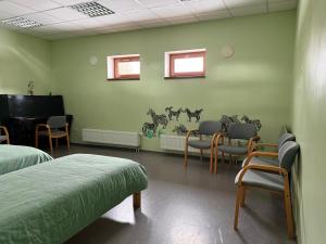 a room with two beds and chairs and a piano at Kuremaa Külalistemaja in Kuremaa