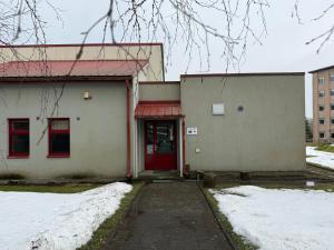 a building with a red door in the snow at Kuremaa Külalistemaja in Kuremaa