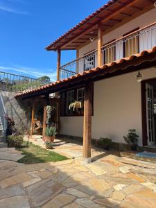 a house with a balcony and a patio at Pedacinho do céu in Tiradentes