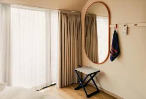 ein Schlafzimmer mit einem Spiegel und einem Tisch vor einem Fenster in der Unterkunft Scandic Go, Grensen 20 in Oslo