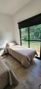 a large bed in a room with a large window at Cabaña Loma Linda in Presidencia Roque Sáenz Peña