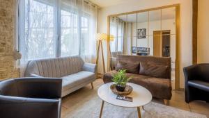 a living room with a couch and a table at Maison Face à Palestra avec Jardin & Confort in Chaumont
