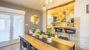 a kitchen with a wooden table and chairs and a dining room at Maison Face à Palestra avec Jardin & Confort in Chaumont