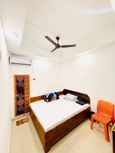 a bedroom with a bed and a ceiling fan at Mannat Lodge in Hailākāndi