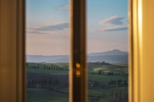 a window with a view of a green field at Casa in Campagna Casagori in Pienza