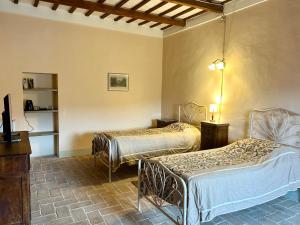 a room with two beds and a tv in it at Palazzo Bruschi in Pergola