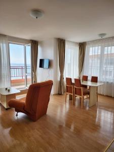 a living room with a table and chairs and a large window at Stunning Beach View Apartment in Ravda