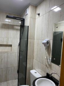 a bathroom with a shower and a toilet and a sink at Hotel Estrela in Cruz Machado