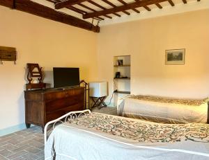 a bedroom with two beds and a dresser in a room at Palazzo Bruschi in Pergola
