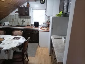 a kitchen with a table and a white refrigerator at Zimmer mit Doppelbett in Zagreb