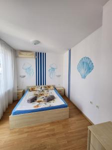 a bedroom with a bed and a blue and white wall at Stunning Beach View Apartment in Ravda +44 photos