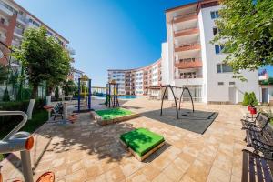 a playground in a courtyard in a building at Stunning Beach View Apartment in Ravda