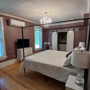 a bedroom with a large bed and a chandelier at Cranberry Moon Inn in Bala
