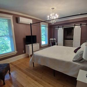 a bedroom with a large bed and a chandelier at Cranberry Moon Inn in Bala
