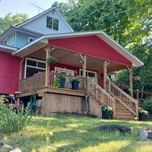 a red house with a deck with flowers on it at Cranberry Moon Inn in Bala