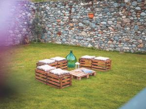 a group of picnic tables in front of a stone wall at Dimora Perla di Villa - Spacious Wine Estate Retreat near Bernina Express in Villa di Tirano