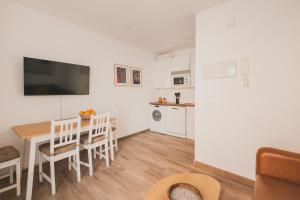 a living room with a dining room table and a kitchen at Alojamiento en Santa Eugenia A in Madrid
