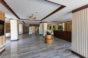 an open hallway with a lobby with columns and a vase of flowers at Paradisos Hotel in Trakhoni