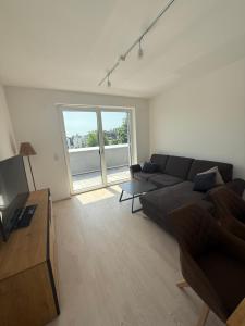 a living room with a couch and a large window at Ferienwohnung Bad Schallerbach in Bad Schallerbach