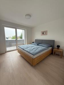 a bedroom with a bed and a large window at Ferienwohnung Bad Schallerbach in Bad Schallerbach