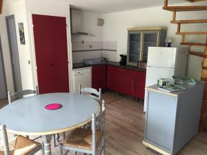 a kitchen with a table and a white refrigerator at Artouste in Laruns