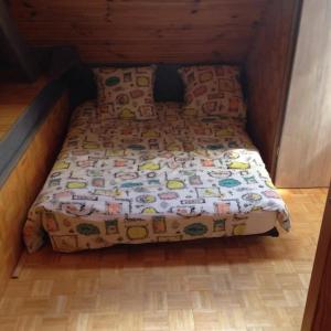 a small bed in a room with a wooden floor at Artouste in Laruns