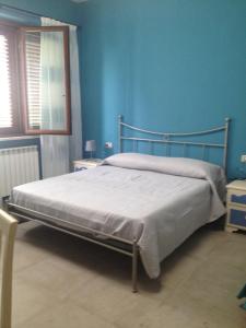 a bed in a blue bedroom with a blue wall at B&B La Torre in Rosello