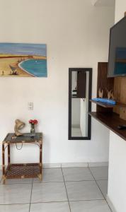 a living room with a table and a mirror at Casa Maré in Aracati