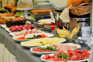 a buffet with many plates of food on a table at Hotel Venezia in Caorle