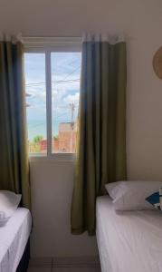 a room with two beds and a window at Casa Maré in Aracati