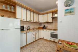 a kitchen with white cabinets and a bowl of fruit at Plac Neptuna Bright Studio with Balcony by Noclegi Renters in Międzyzdroje +9 photos