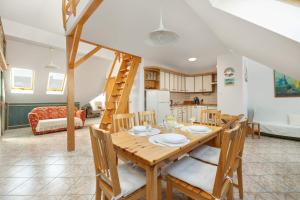 a kitchen and dining room with a wooden table and chairs at Plac Neptuna Bright Studio with Balcony by Noclegi Renters in Międzyzdroje