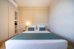 a bedroom with a white bed with blue pillows at Beach Park Resort - Suites in Aquiraz +80 photos