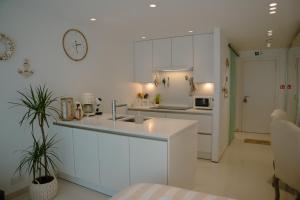 a white kitchen with a sink and a counter at The White coast studio in Nieuwpoort