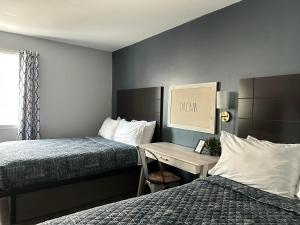 a hotel room with two beds and a desk at Mainstay Inn in Phoenixville