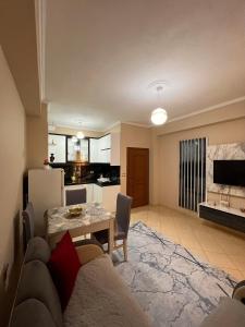 a living room with a table and a kitchen at Kapo Apartments in Gjirokastër