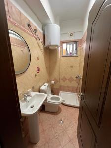 a bathroom with a sink and a toilet and a mirror at Kapo Apartments in Gjirokastër +68 photos