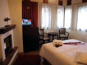 a hotel room with a bed and a fireplace at Hotel Mirovoli in Mileai
