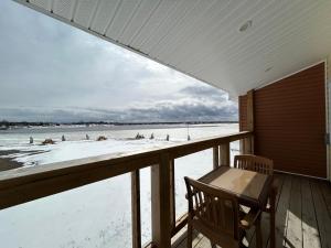 a porch with a table and a chair on a beach at Cocagne Ocean Suites- Bed & Breakfast in Cocagne 