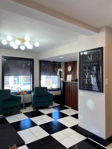 a lobby with two chairs and a poster on a wall at Mainstay Inn in Phoenixville