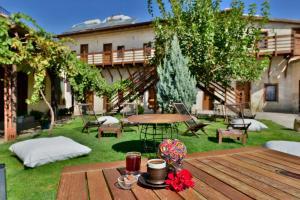 a wooden table in a yard with a picnic table and chairs at The Loop Cappadocia in Avanos