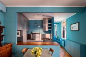 a kitchen with blue walls and a table with flowers on it at Paruta Jazz Apartment in Venice