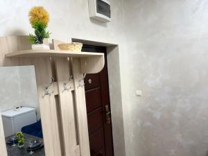 a room with a toilet and a door with a shelf at Cozy Corner 41 in Ruse