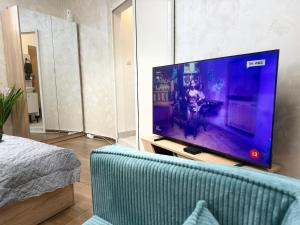 a living room with a large tv and a couch at Cozy Corner 41 in Ruse