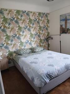 a bedroom with a bed with a floral wallpaper at Les Cyclamens in Cosne-Cours-sur-Loire