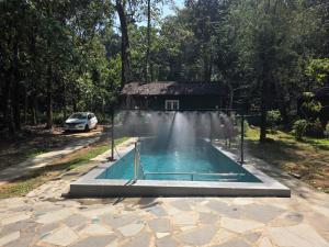 a swimming pool in front of a house at The Nest Thattekad, A Junge Retreat with Pool in Thattakād