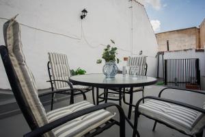 a table and chairs on a balcony with a vase on it at Casa Lombarda in Mérida