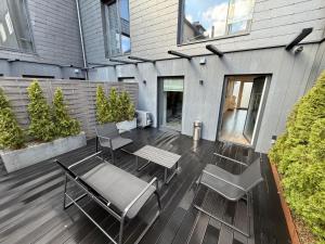 a patio with chairs and a table and a bench at Jacuzzi Cinema Loft in Kaunas