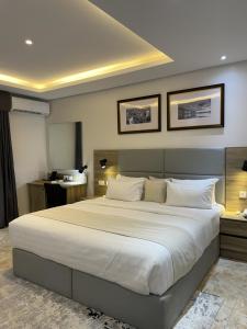 ein Schlafzimmer mit einem großen Bett mit weißer Bettwäsche in der Unterkunft Ringruby Hotel, Oladipo Bateye in Lagos + 24 Fotos